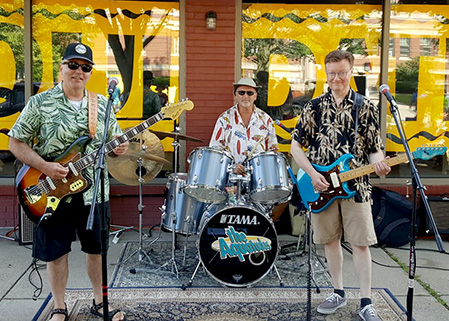 image of the aquatudes standing in front of a storefront